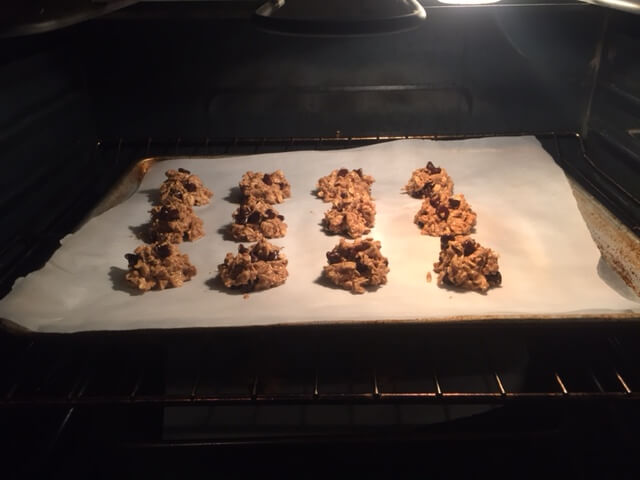 scoops of cookie dough on a pan baking in the oven
